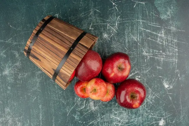 red apples falling out of bucket